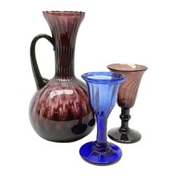 19th century amethyst drinking glass, the wrythen twist bell shaped bowl upon a knopped stem and circular foot, H11cm, together with a 19th century amethyst glass ewer, with lightly moulded bulbous body and fluted neck, H19cm, and a 19th century blue drinking glass, the ogee lightly moulded bowl with folded rim upon a conforming moulded stem and conical foot, H10.5cm