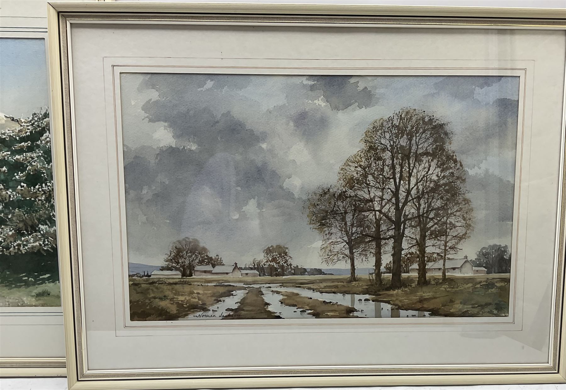 Norman Jackson (British 20th century): Sunset Lake Landscape and Flatland Landscape with Hilly Scene, pair watercolours together with a smaller by the same hand, signed max 31cm x 51cm (3)