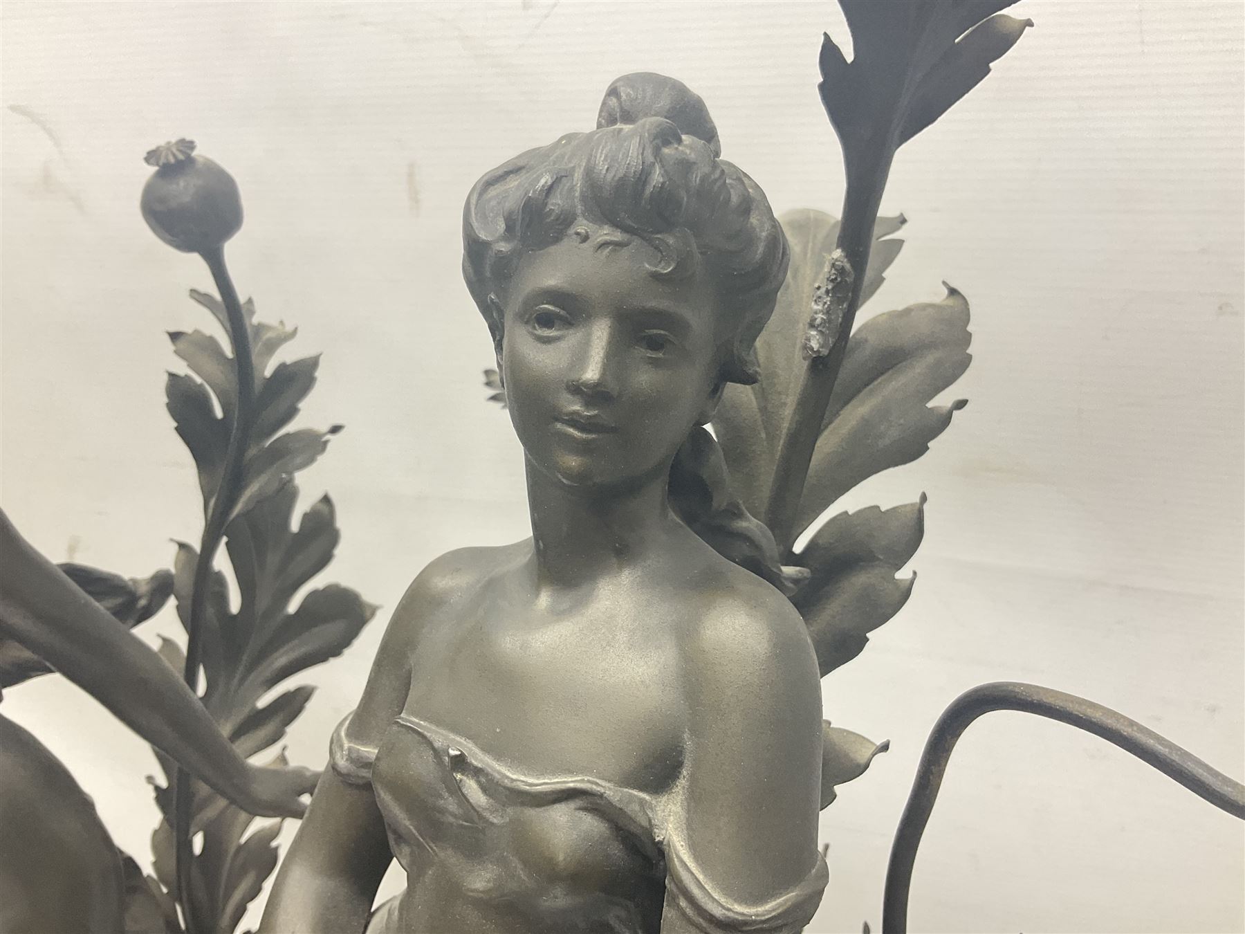Pair of Art Nouveau style spelter figural table lamps, each mounted on rouge marble effect circular bases, with toleware flower heads and leafy decoration surrounding a female figure, H90cm