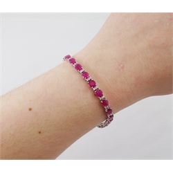 18ct white gold ruby and diamond bracelet, twenty-six oval cut rubies, each spaced by two round brilliant cut diamonds, hallmarked, total ruby weight approx 9.40 carat, total diamond weight 0.50 carat