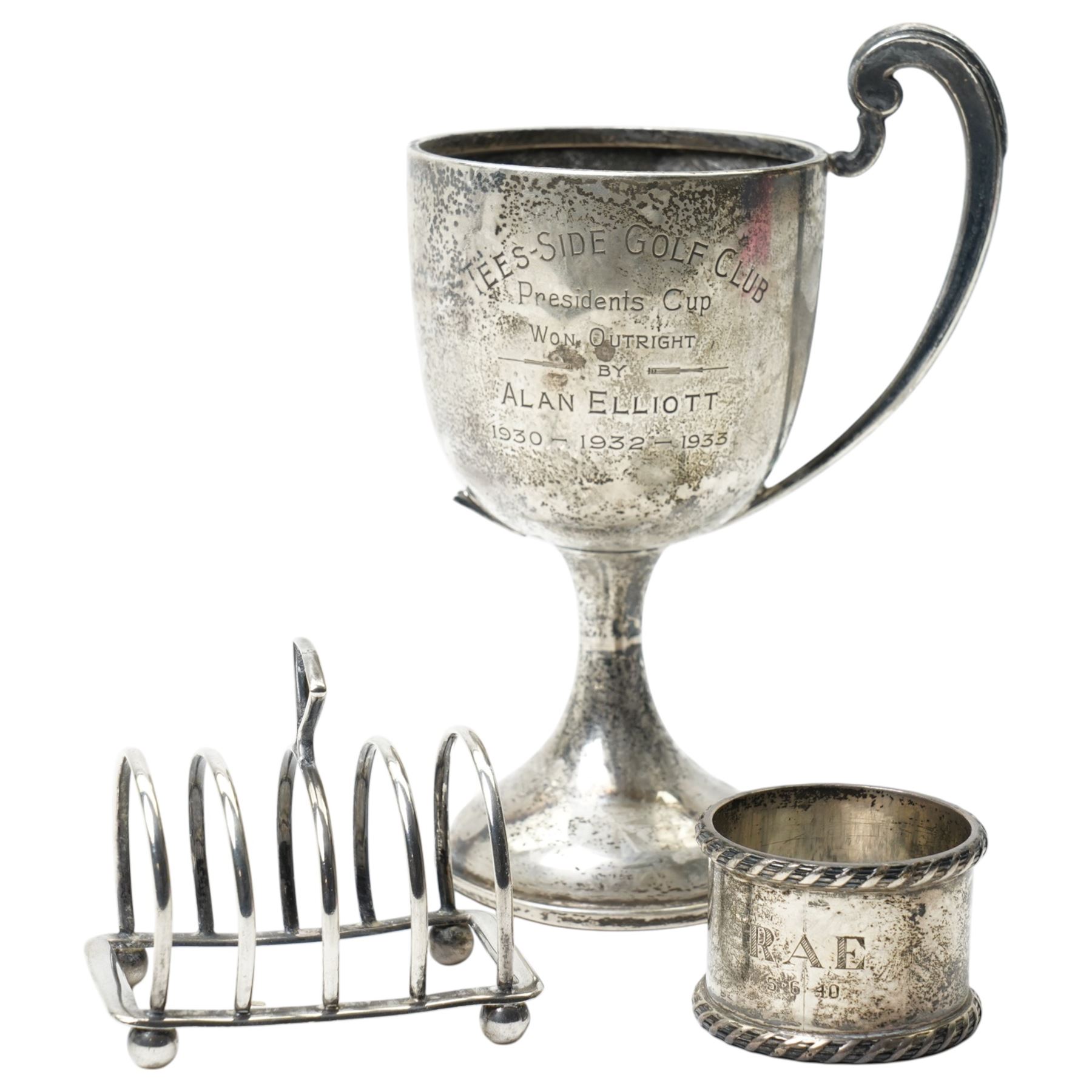 Silver trophy, small silver toast rack and a silver napkin ring