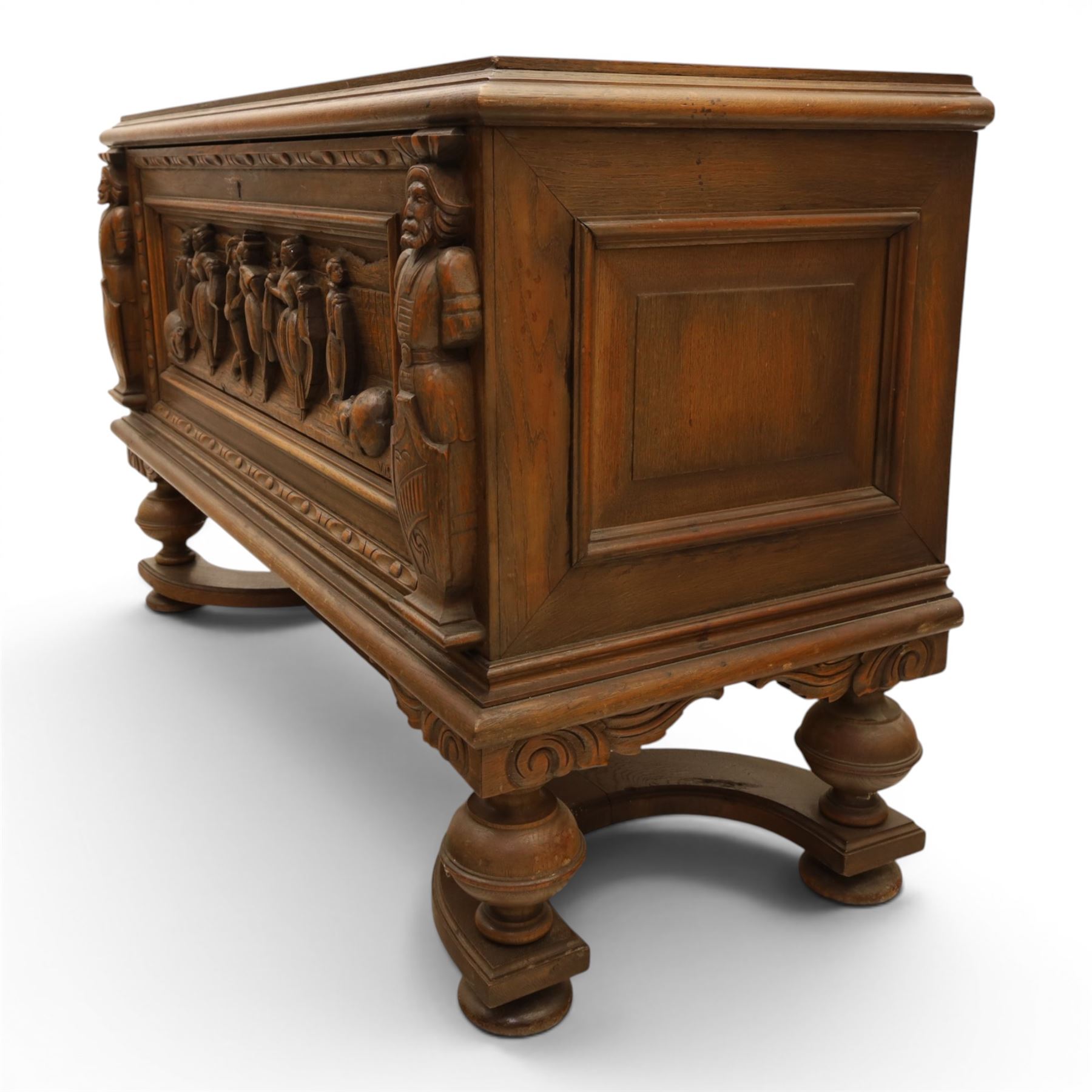 Carved oak coffer bench, rectangular moulded top above carved fall front, with figural, mask and foliate decoration, panelled sides, raised on turned bun feet with shaped lower apron