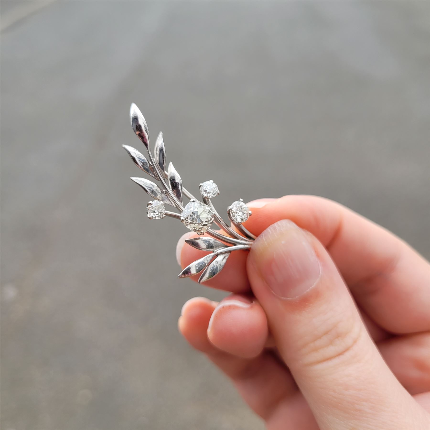18ct white gold diamond flower brooch, set with a principal old cut diamond of approx 1.00 carat, surrounded by three further old cut diamonds, total diamond weight approx 1.75 carat