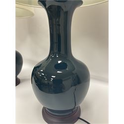 Pair of Chinese teal glazed table lamps, each of bottle form, raised upon circular hardwood bases, including shade H72cm 