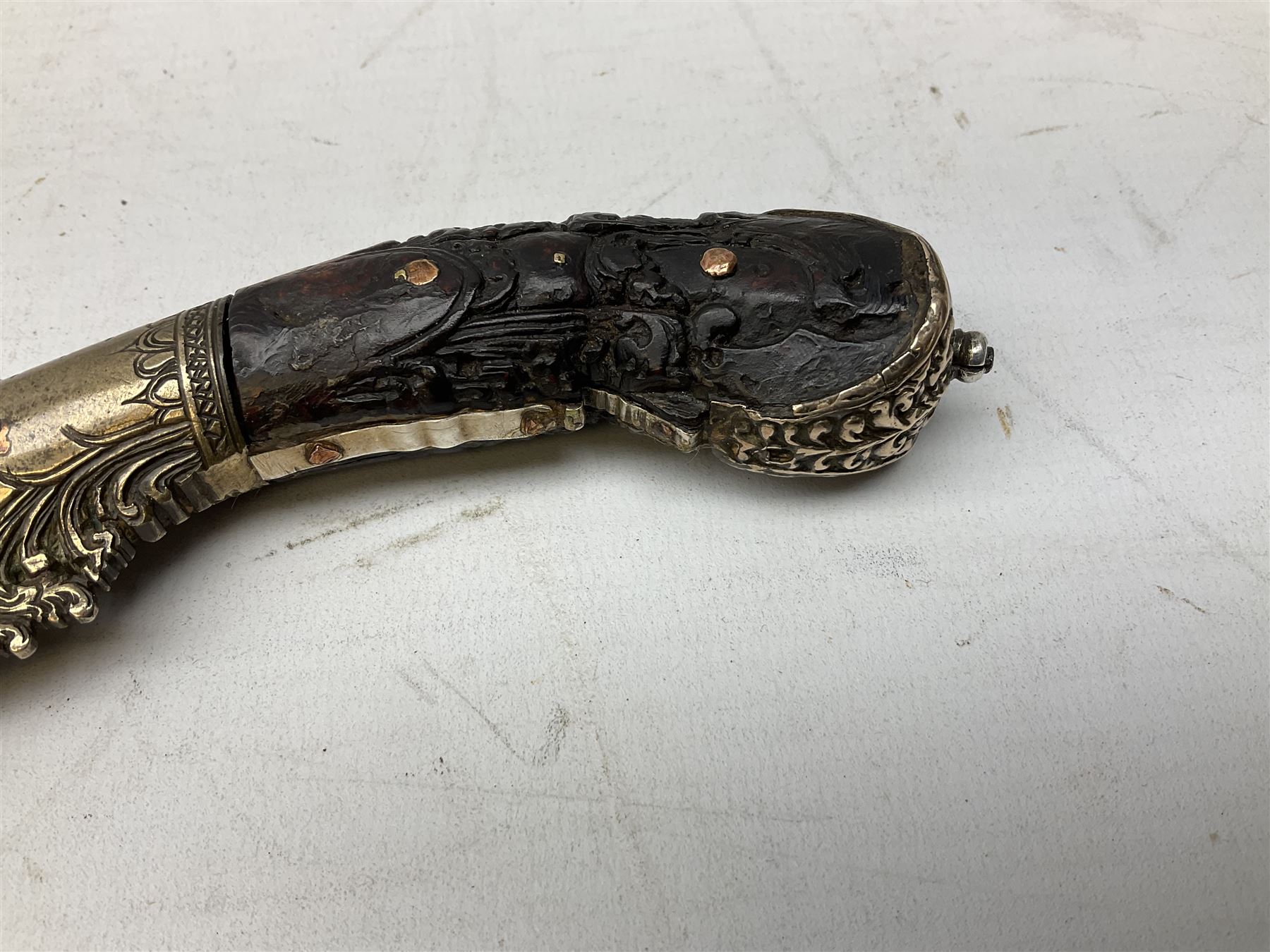 19th century Singhalese knife pia kaetta, the 20cm steel blade inset with yellow and white metal, with metal mounted carved pistol grip, in plain wooden scabbard L33cm overall