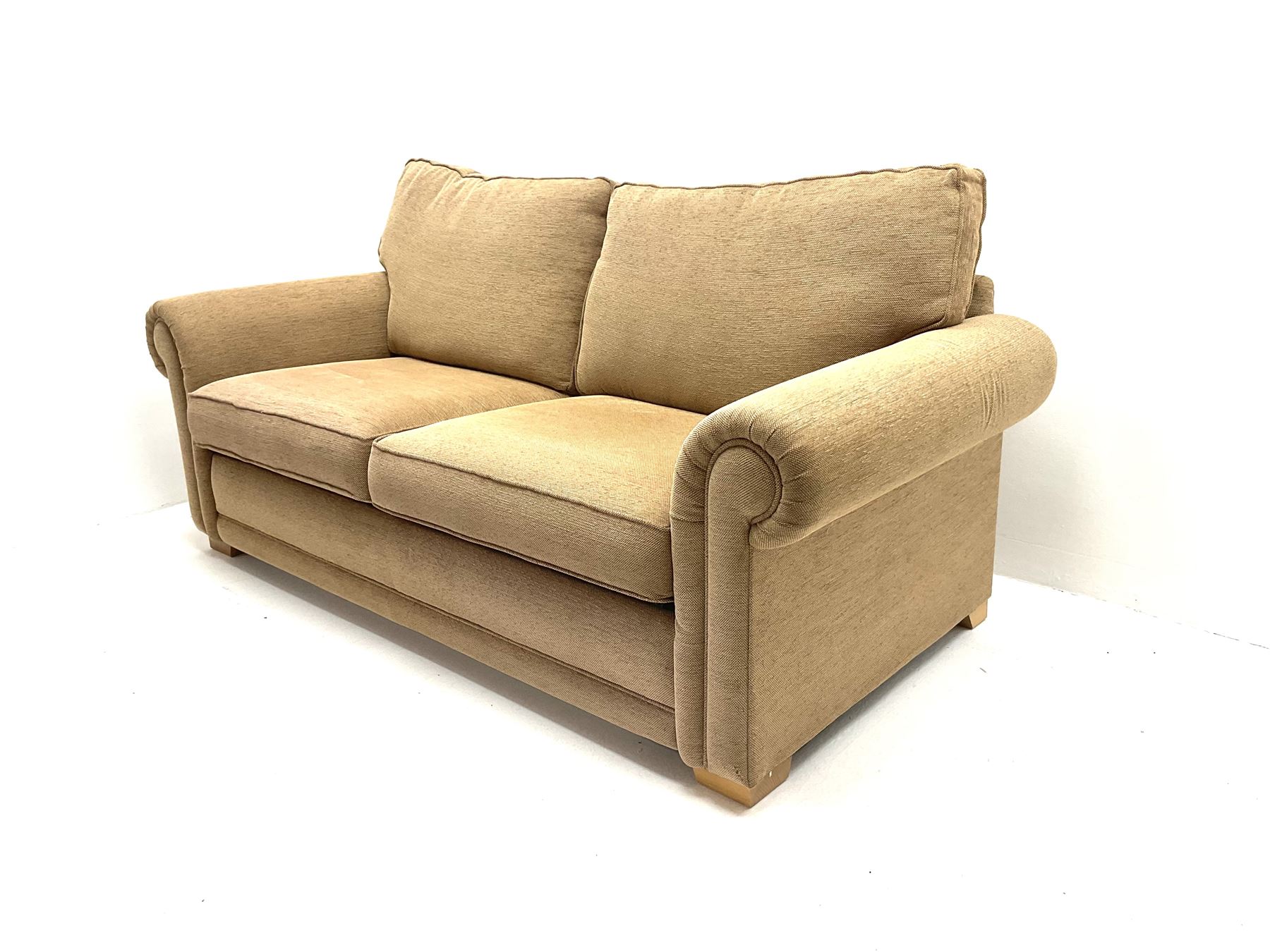 Two seat sofa bed, upholstered in ochre coloured fabric, block supports