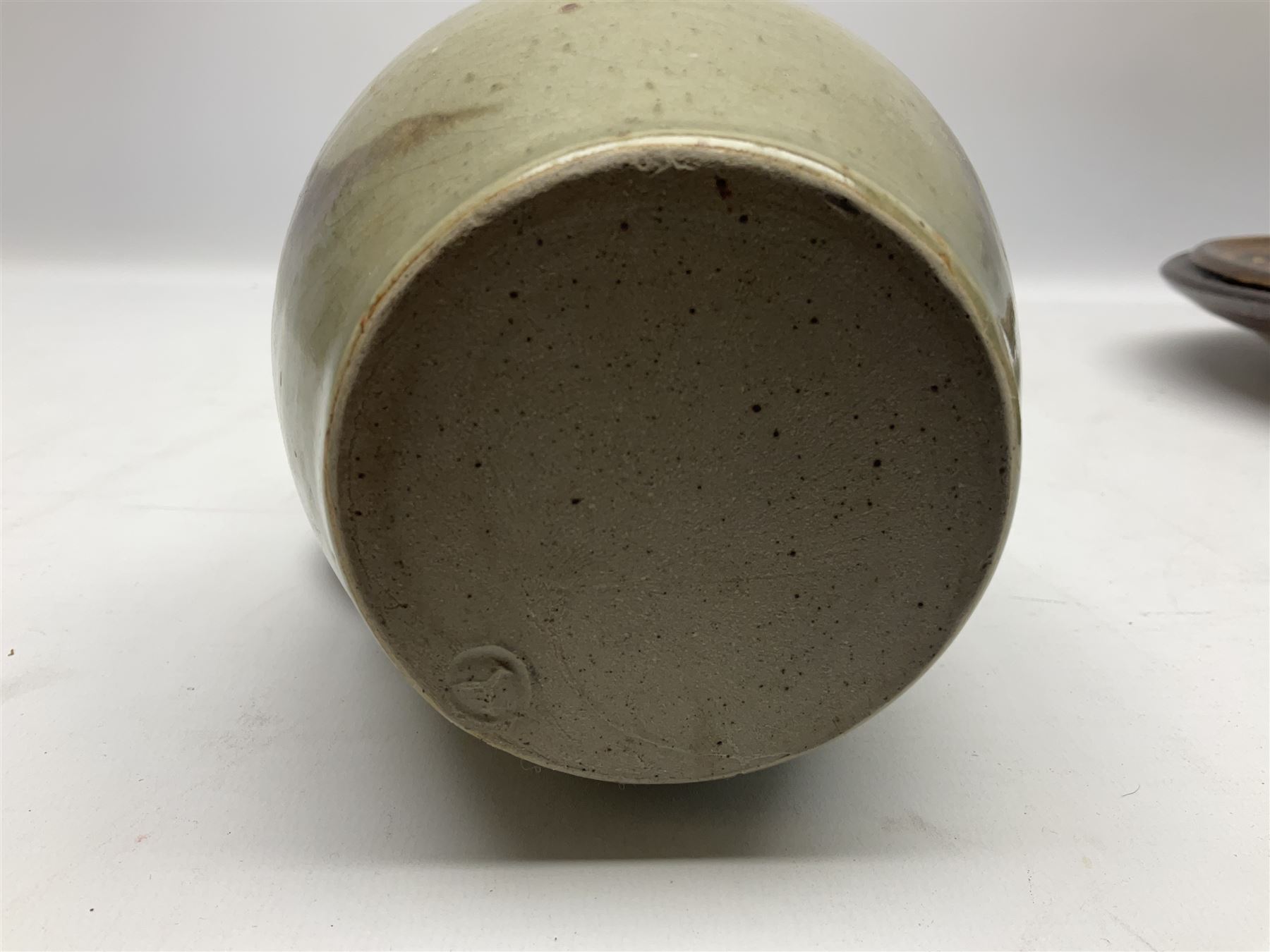 Michael Leach (British 1913-1985) for Yelland pottery; two large glazed stoneware plates with dark brown stylised decoration upon oatmeal ground, together with a jug in merging blue, green and brown, all with impressed marks beneath, largest plate D37cm