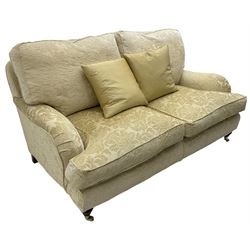 Multi-York - Howard shape two-seat sofa, upholstered in scrolling floral pattern loose covers, rolled arms, on turned front feet with brass cups and castors