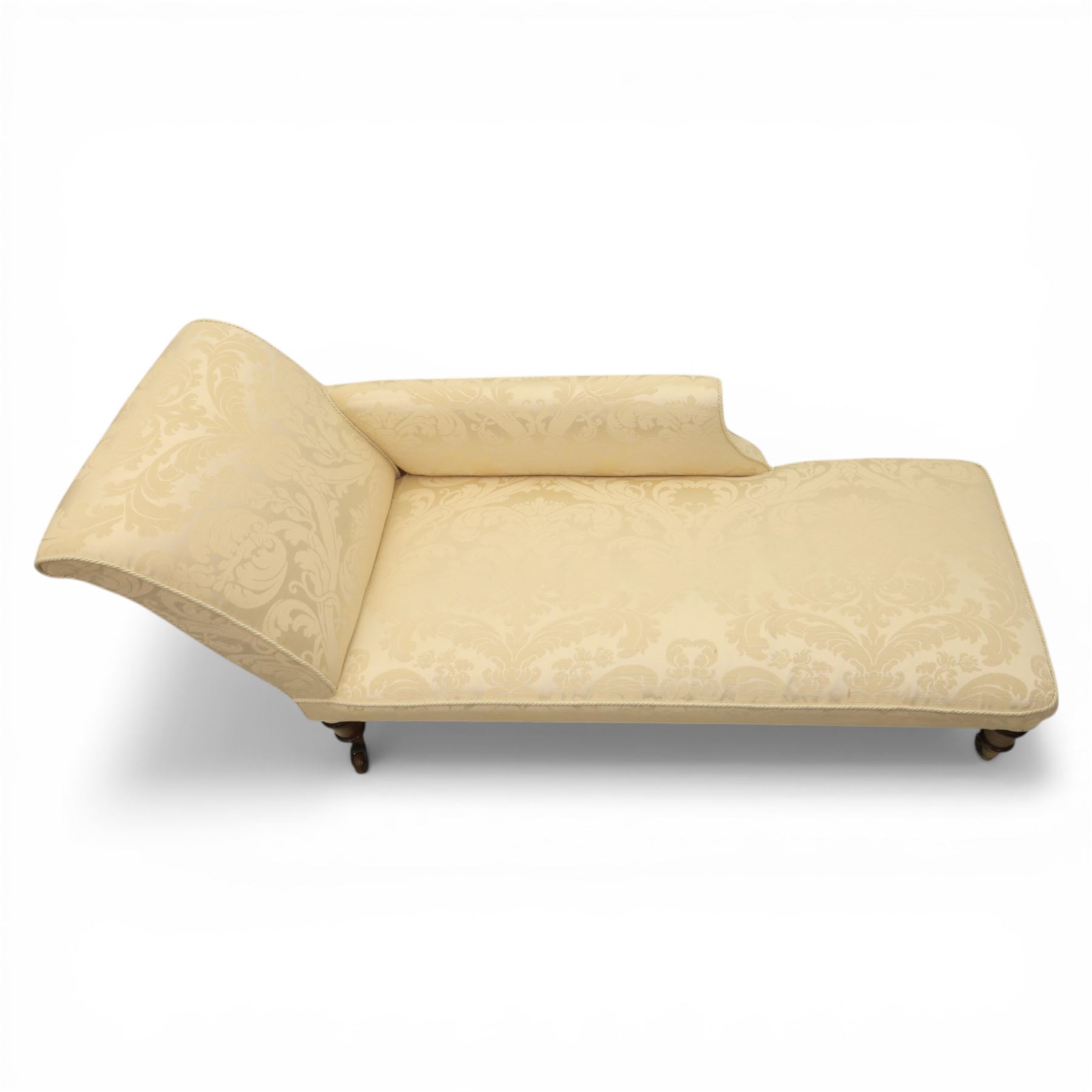 Victorian chaise longue upholstered in ivory damask fabric, padded back and armrest with rope piping, raised on turned feet with castors