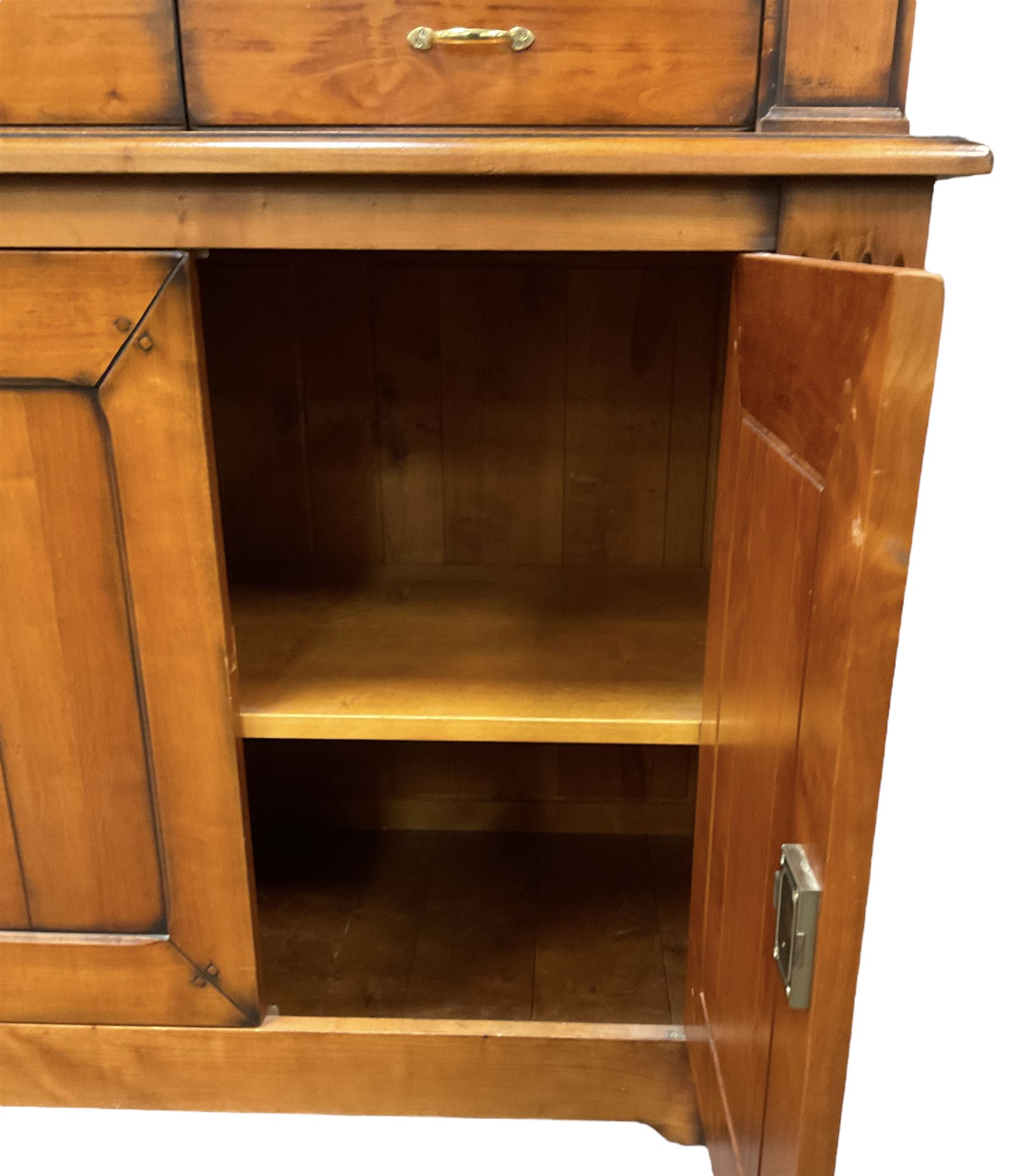 French cherry wood bookcase on cupboard, projecting moulded cornice over three shelves and two small drawers, the cupboard enclosed by two panelled doors flanked by fluted uprights