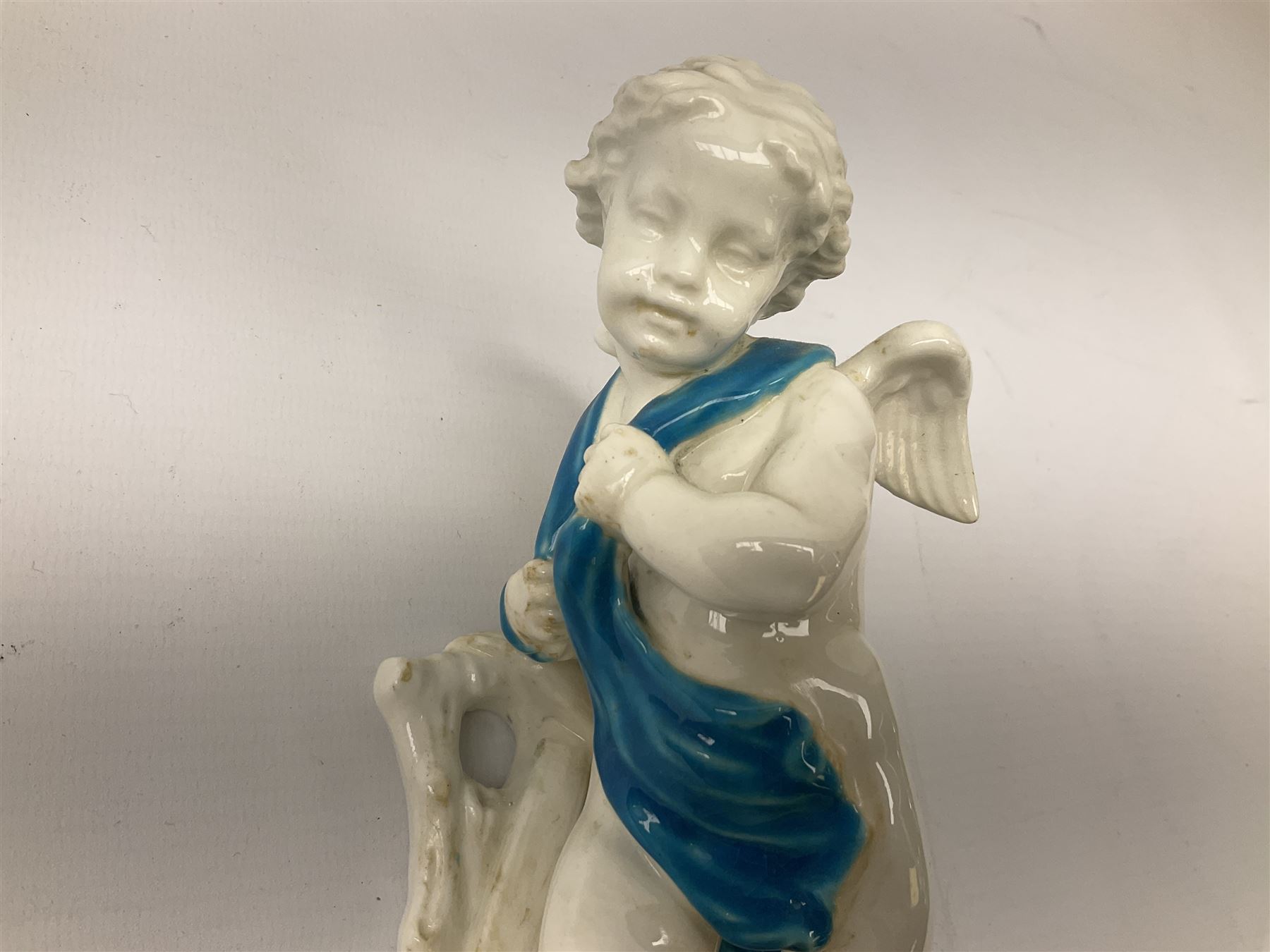 Victorian wall pocket by Moore Brothers retailed by T.Goode modelled as a semi nude white glaze cherub with turquoise ribbon, with encrusted floral decoration, the reverse stamped ‘T.Goode & Co.’, H32cm