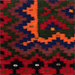 North East Persian Sumak flatweave kilim, woven with an all-over arrangement of stepped diamond motifs, including a diagonal band of contrasting colours in shades of red, indigo, green, pink, and ivory, framed by multiple geometric borders incorporating serrated chevron designs  