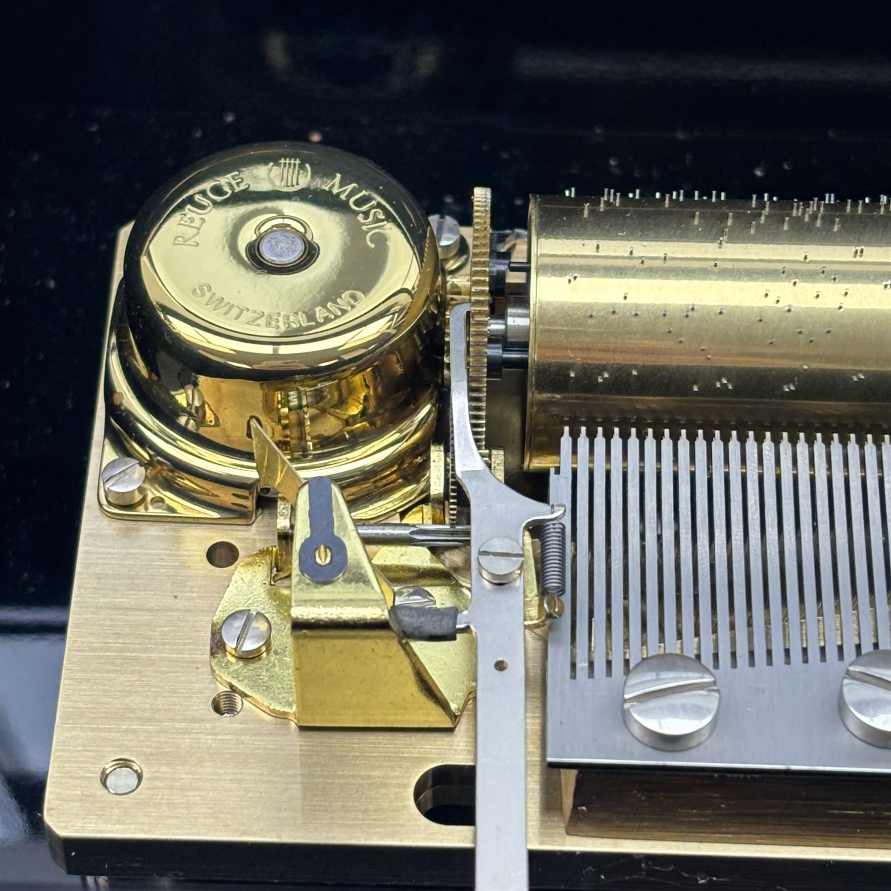 Reuge Sainte-Croix- 21st century Swiss musical box with a highly polished lacquered finish, inlaid and ebonised case with a glazed internal viewing lid, polished steel 144 teeth two-part comb playing three arias from The Phantom of the Opera by Lloyd Webber, with tune indicator and tune sheet.