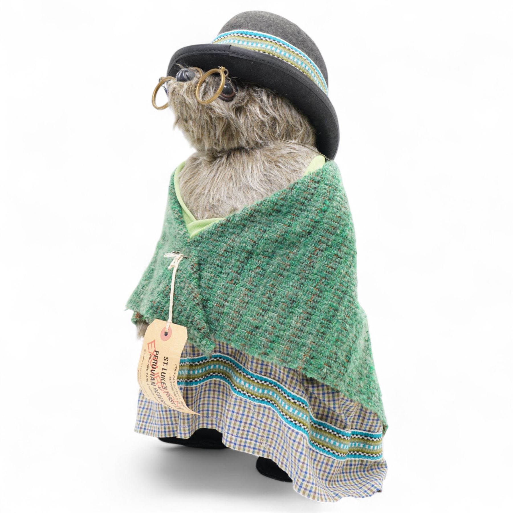 Gabrielle Designs Paddington Bear 'Aunt Lucy', 1978, dressed in green shawl, with hat and spectacles, tartan dress and luggage tag from the Peruvian Rugby FC Reserves Supporters Club, H50cm
