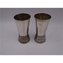 Pair of modern Guild of Hull Silversmiths silver goblets, the bowls each of tapering cylindrical form, with spot hammered finish, upon a tapering foot, etched with abstract lines, hallmarked J & KR, Birmingham 1983, also marked with the three crowns mark of the Guild of Hull Silversmiths, H11.6cm
Notes: Abraham Barachin was the last Hull silversmith to use the Hull mark of three ducal coronets in around 1706. However in 1983 the Assay Offices of Great Britain and the City of Kingston upon Hull granted the Guild of Hull Silversmiths permission to use the City's Coat of Arms as an additional mark on pieces they produced