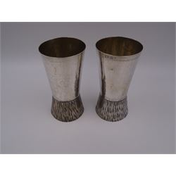 Pair of modern Guild of Hull Silversmiths silver goblets, the bowls each of tapering cylindrical form, with spot hammered finish, upon a tapering foot, etched with abstract lines, hallmarked J & KR, Birmingham 1983, also marked with the three crowns mark of the Guild of Hull Silversmiths, H11.6cm
Notes: Abraham Barachin was the last Hull silversmith to use the Hull mark of three ducal coronets in around 1706. However in 1983 the Assay Offices of Great Britain and the City of Kingston upon Hull granted the Guild of Hull Silversmiths permission to use the City's Coat of Arms as an additional mark on pieces they produced