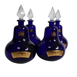 Set of four 20th century Royal Pharmaceutical Society blue glass bottles, of bellied form with clear cut glass spire stopper, each body bearing gilt label in Latin: VIN:ACET:, VIN:ANTIM:, VIN:XERIC:, and VIN:FERR:, and gilt Royal Pharmaceutical Society crest to neck, H25cm

Provenance: From the collection of the family of Peter Green, a practising pharmacist whose career spanned the mid to late 20th century. During his professional life he managed pharmacies in Yeovil, Somerset, and later Selles Chemist in Filey, North Yorkshire, before purchasing and running his own business, Peter Green Pharmacy, located in the Market Place, Malton. The bottles were displayed as part of the traditional shop fittings in both the Filey and Malton pharmacies and were retained as part of his collection.