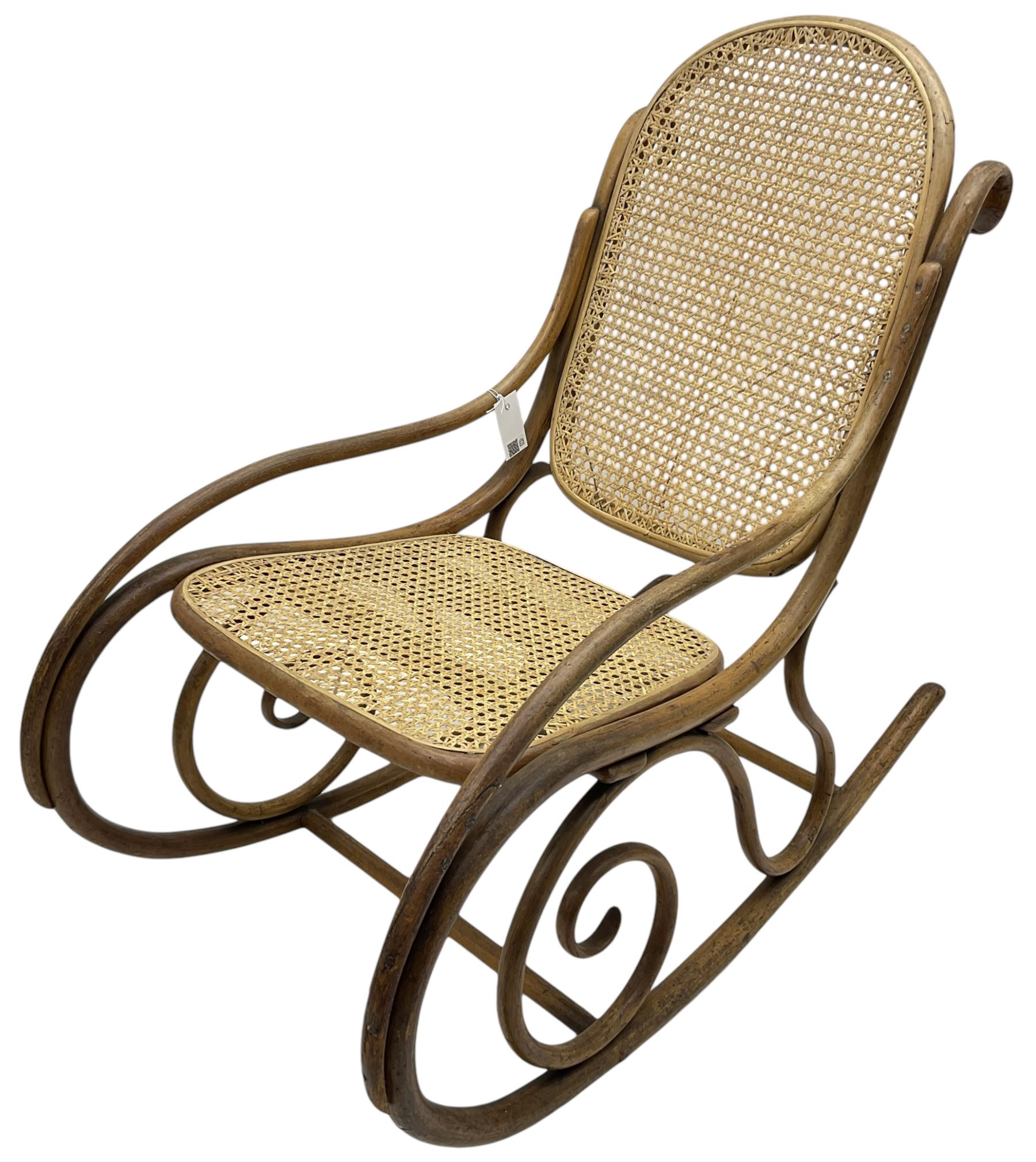 Early 20th century Michael Thonet design bentwood rocking chair, with cane seat and back (W52cm H82cm); Edwardian rocking chair with mauve upholstered back and seat (W43cm H70cm)