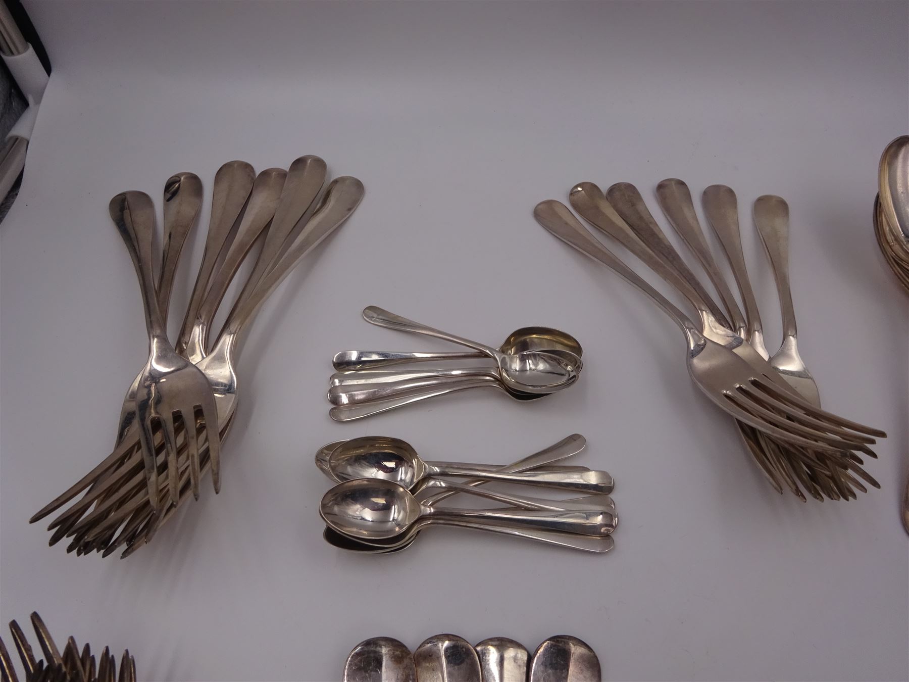 1930s matched set of silver Hanoverian pattern flatware, each with rattail bowls, to include four table spoons, twelve dessert spoons, twelve table forks, twelve dessert forks, twelve teaspoons and twelve coffee spoons, all hallmarked with various makers and dates 