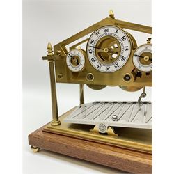 Mid 20th century 'Congreve' rolling ball clock, sloped arch and pierced brass movement, the central Arabic minute chapter ring flanked by hour and seconds dials, twin train driven eight day movement, raised on mahogany plinth with turned brass feet, under acrylic cover