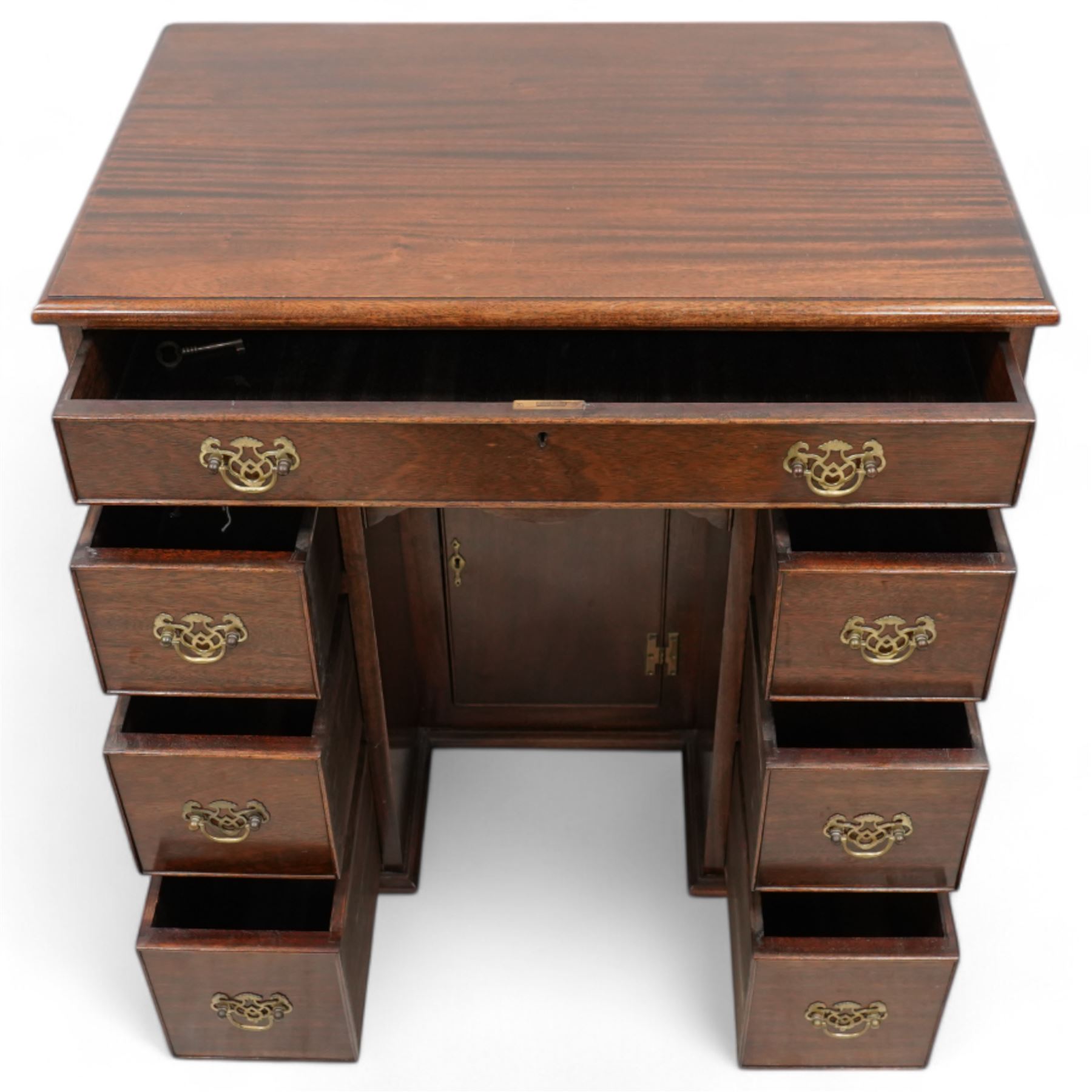 Georgian design mahogany kneehole desk, moulded rectangular top over single drawer, shaped frieze drawer and six short drawers, recessed kneehole with cupboard, on bracket feet