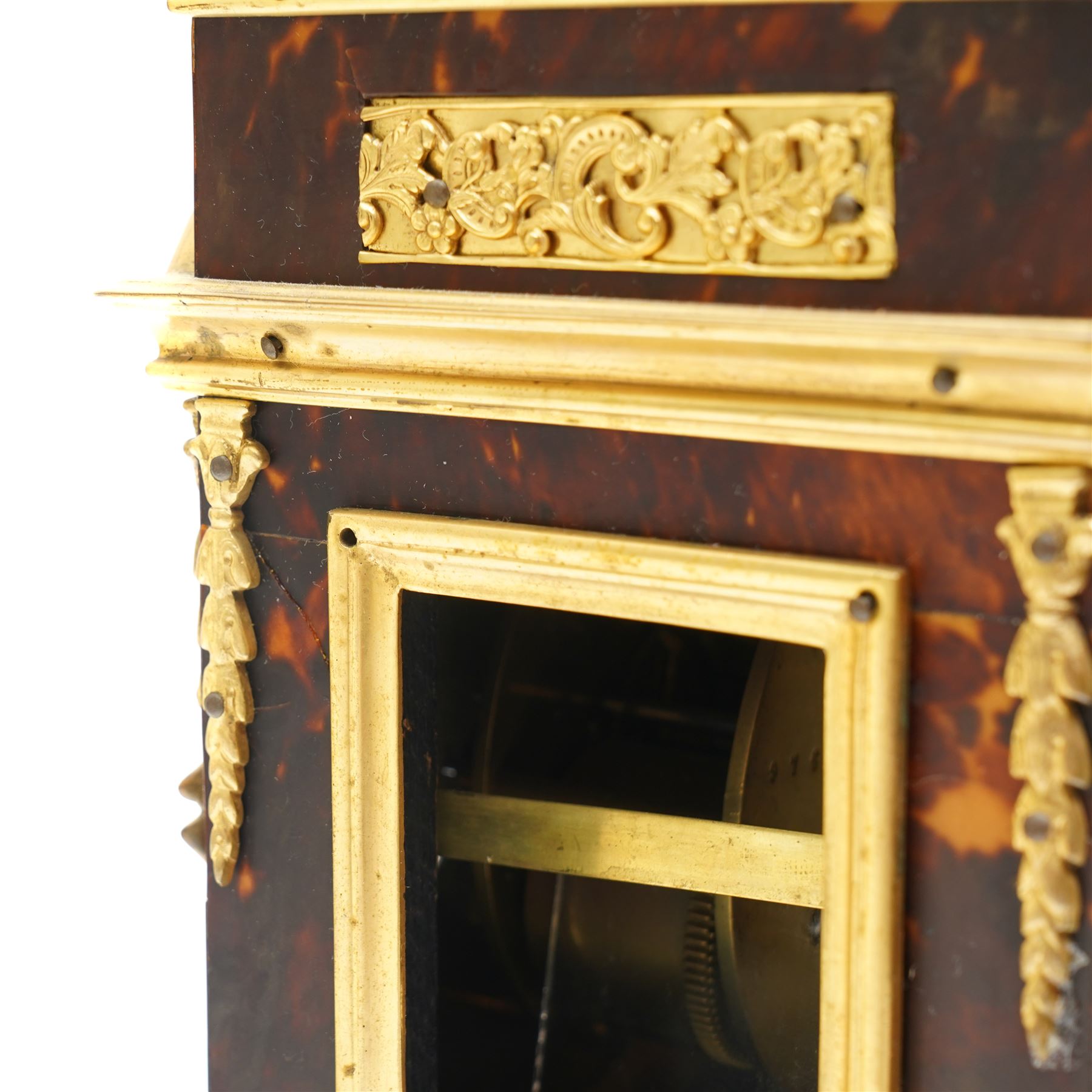 French-late 19th century brown stained 8-day faux Tortoise shell and ormolu mounted mantle clock, rectangular case with glazed side panels and shaped pediment with matching finials, convex enamel dial with Roman numerals, minute track and steel moon hands within a cast brass glazed dial bezel,
twin barrel movement with rack striking, striking the hours and half hour on a coiled gong. With pendulum and key.