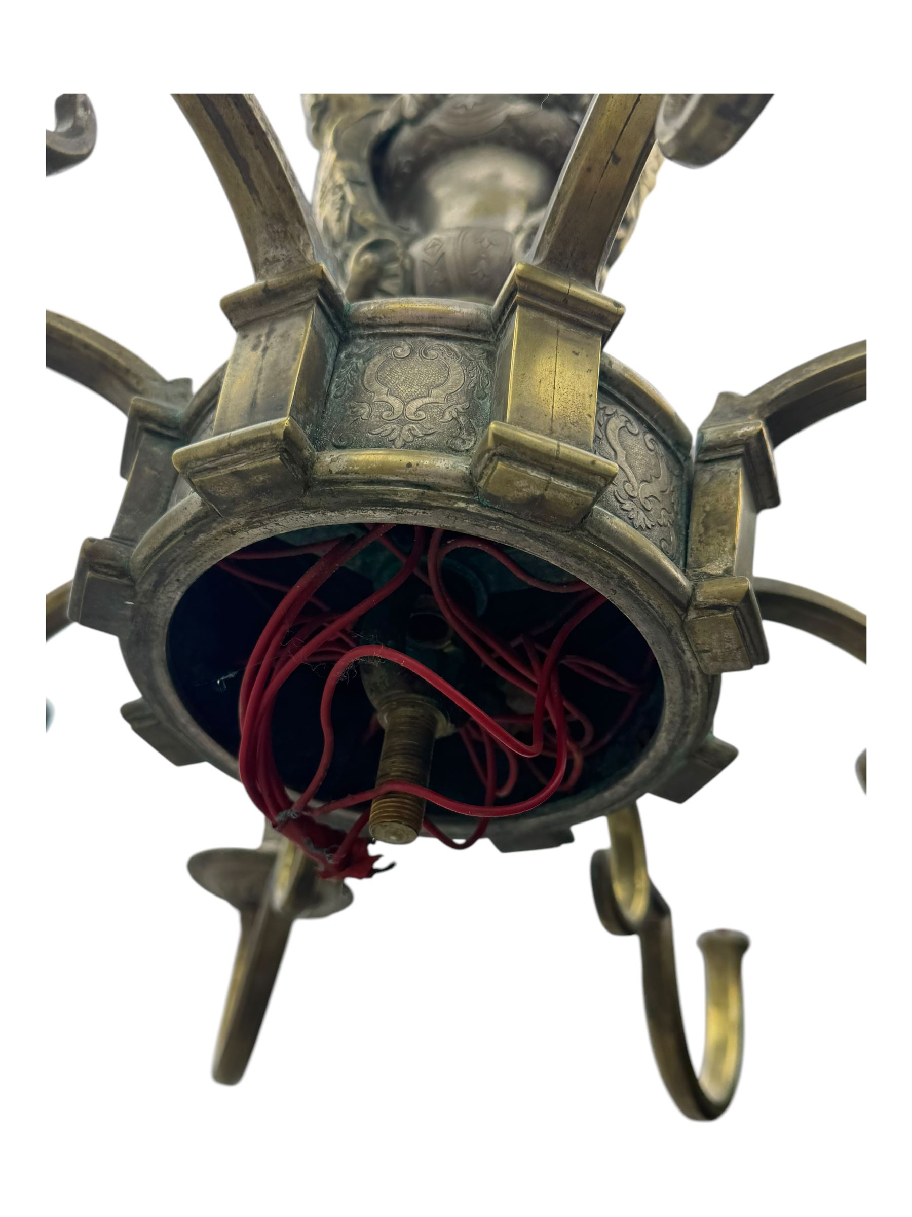 Early 20th century cast brass chandelier, the main baluster-form body surmounted by a lobed finial, with three cherubic heads and foliate scrollwork around the upper section, eight sweeping branches for lights
