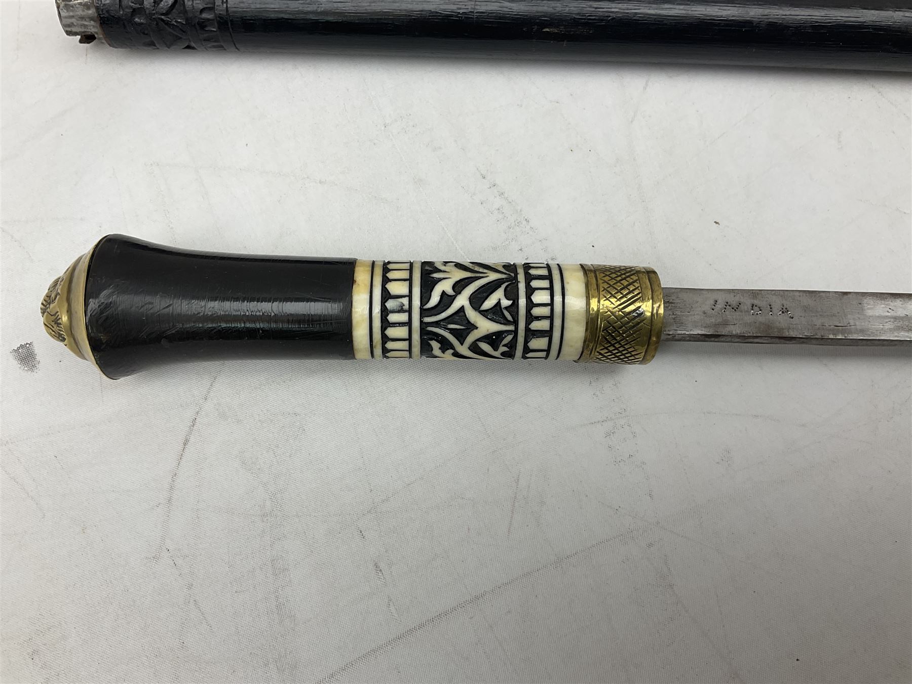Late 19th/early 20th century Anglo Indian ebony and bone sword stick with 62cm steel blade, brass locking ferrule and lion mask pommel L92 cm.