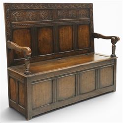 Victorian Jacobean Revival carved oak settle or hall bench with box seat, the cresting rail carved with repeating lunette motifs with acanthus and rosette decoration, over four back panels and hinged box seat, the panelled base raised on stile supports