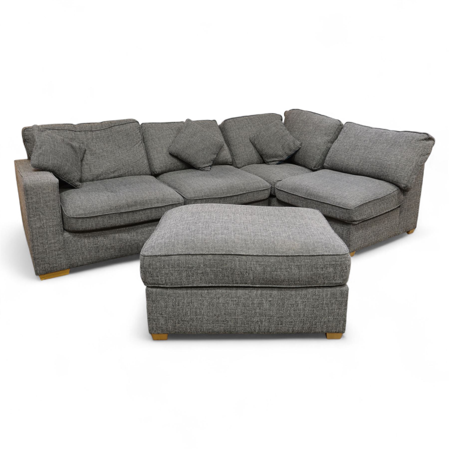 Contemporary grey fabric corner sofa and ottoman, comprising modular sections with removable back and seat cushions, raised on light wood block feet