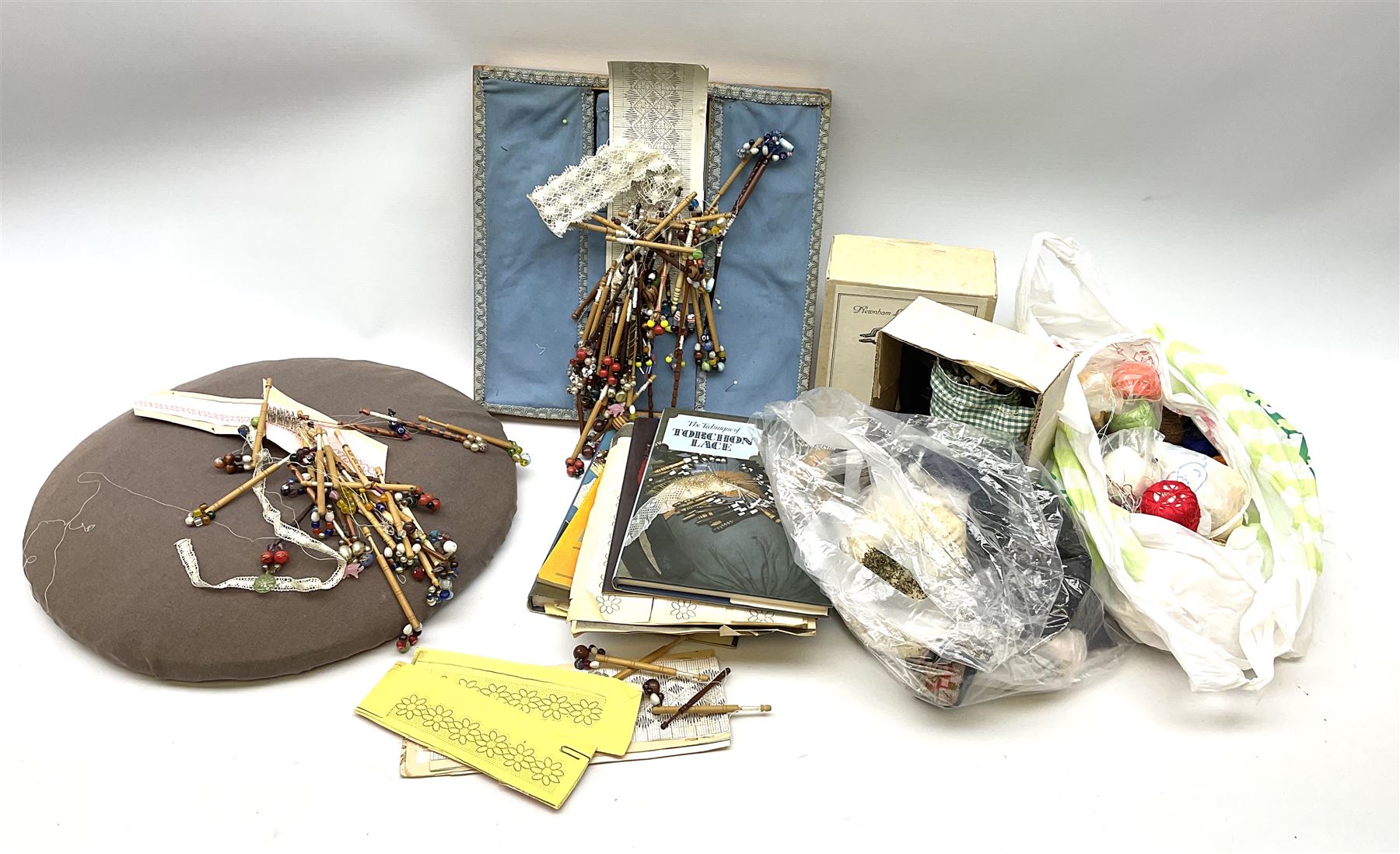 A quantity of lace making equipment, to include pillows, wooden bobbins, boxed bobbin winder, books, etc. 