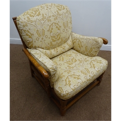  Ercol medium elm framed armchair, carved cresting rail, turned splat and legs joined by stretchers, upholstered with light gold floral back and seat cushions, W88cm  