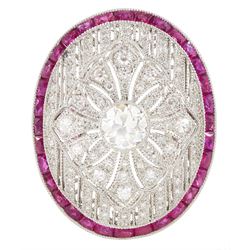 Platinum diamond and ruby oval cluster ring, principal transitional cut diamond of approx ...