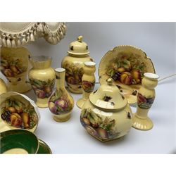 Collection of Aynsley Orchard Gold pattern wares, comprising lamp base, three jars and covers, six vases or various size and form, large jug, lidded dish, pair of cruets, pair of candlesticks, mug, two pin dishes, lobed dish, tea cup, saucer, size plate, and cake plate, and two further cups and saucers, each cup decorated with central Orchard Gold reserve to the interior against a mottled pink or green ground. 