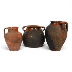 Three early 20th century Spanish part glazed terracotta storage vessels, the first example...