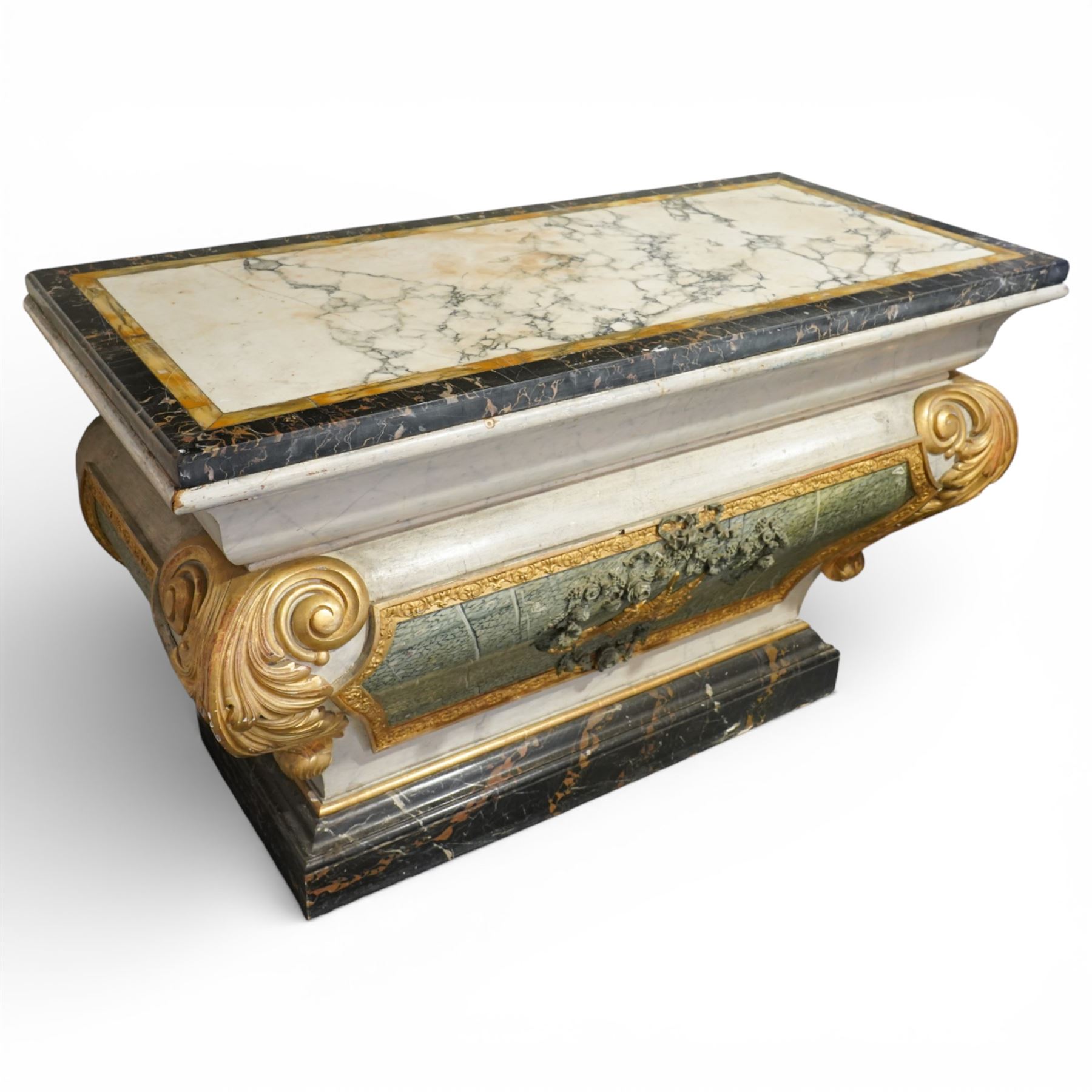 A 20th century Italian Neoclassical console table of architectural pedestal form, inspired by Roman architectural prototypes, with marble top and simulated marble scagliola-type finish; the rectangular marble top with grey veining within a black and yellow marble border, above a pedestal base finished in a finely executed faux-marble surface and enriched with parcel-gilt scrolling acanthus terminals, floral garlands, a central ribbon-tied motif in relief, and further raised flowerheads and a central gilt monogram, terminating in a stepped plinth base