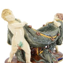 Late 19th century Copeland majolica centrepiece, circa 1874, modelled as two putto standing with fishing net draped between them, their catch spilling onto the quatrelobed base beneath, with impressed mark beneath, H24cm W33cm 