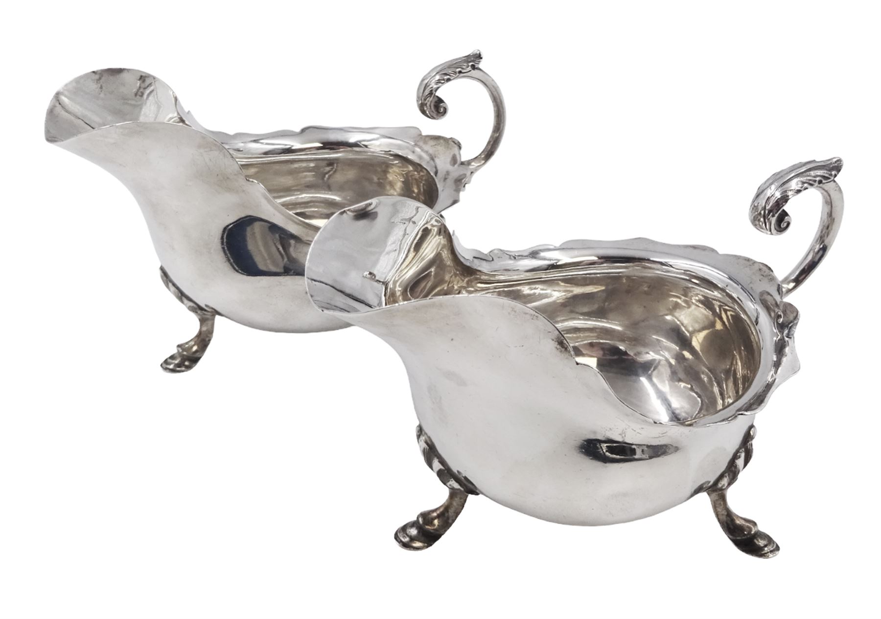 Pair of silver sauce boats, of typical plain form, with acanthus capped flying scroll handle and each upon three hoof feet, hallmarked Walker & Hall, Birmingham 1901, H9cm