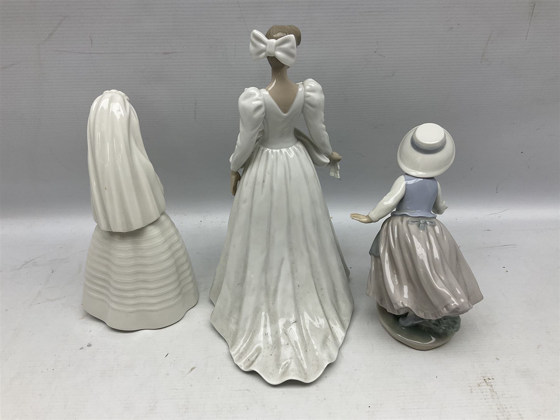 Three Nao figures comprising The Next Dance 1201 and Girls First Communion 0236, and young girl wearing a hat, together with two further Spanish style figures