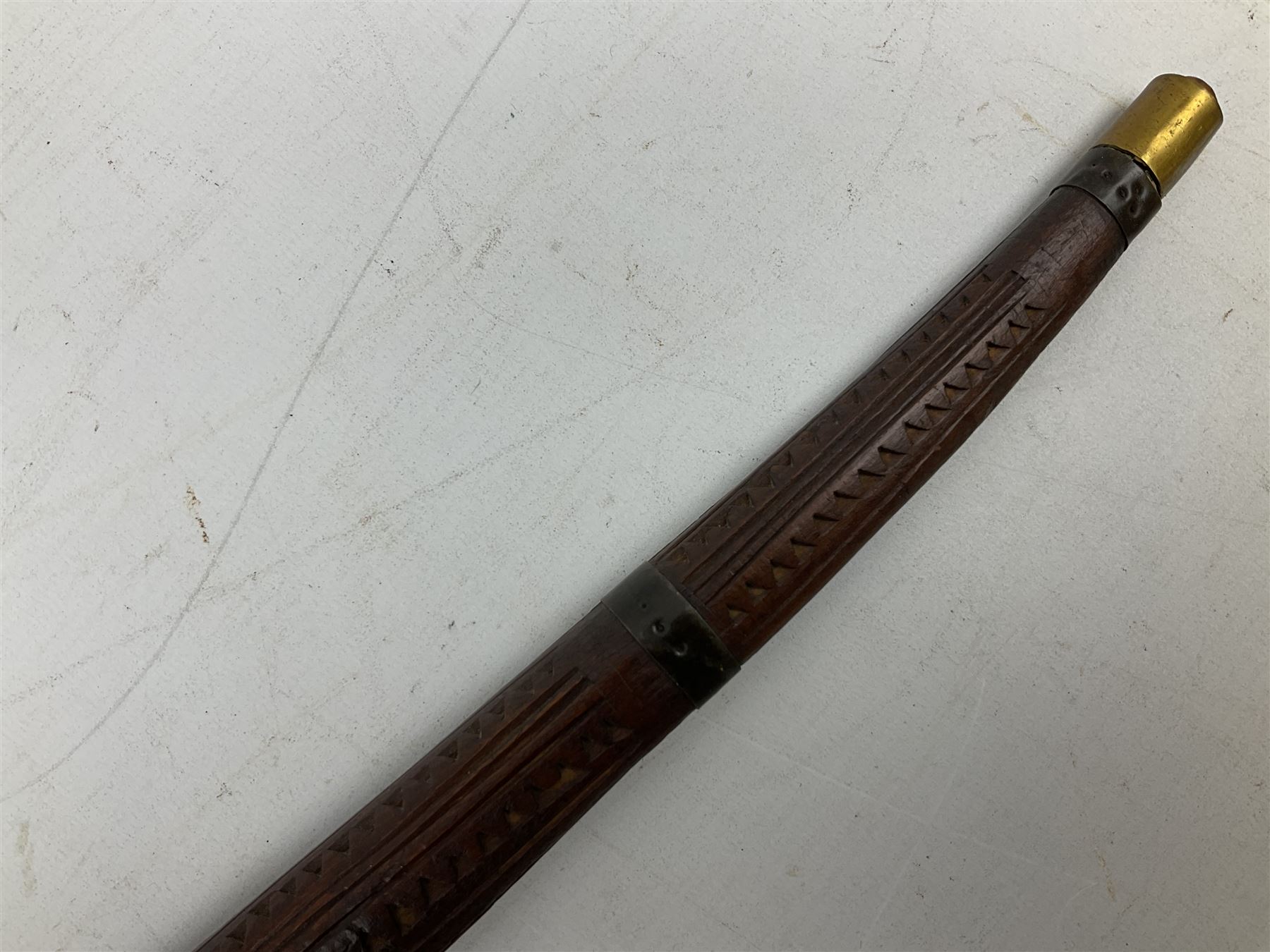 19th century Algerian Flyssa long knife, the 34cm single edged pointed decorative blade inset with yellow metal, chased brass grip with pommel as the snout of a stylised animal and carved hardwood scabbard L45cm overall