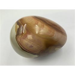 Polychrome jasper specimen egg, in creams, browns and earthy tones, upon a wooden stand, H12cm
