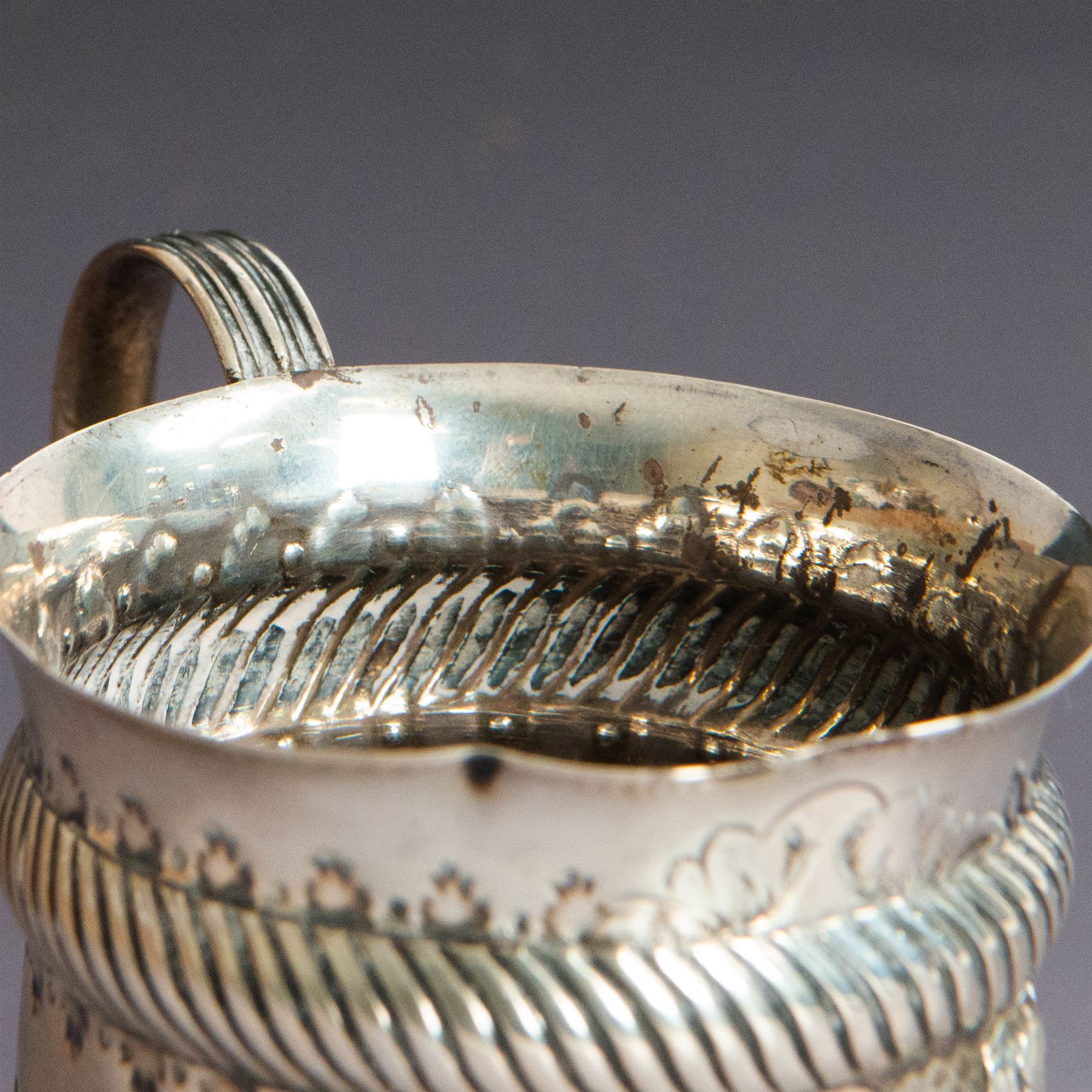 Victorian silver christening mug, of circular form with C scroll handle, embossed with scrolls and foliate decoration, with vacant oval cartouche to body, hallmarked John Aldwinckle & Thomas Slater, London 1890, contained within a tooled leather fitted case, mug H8cm
