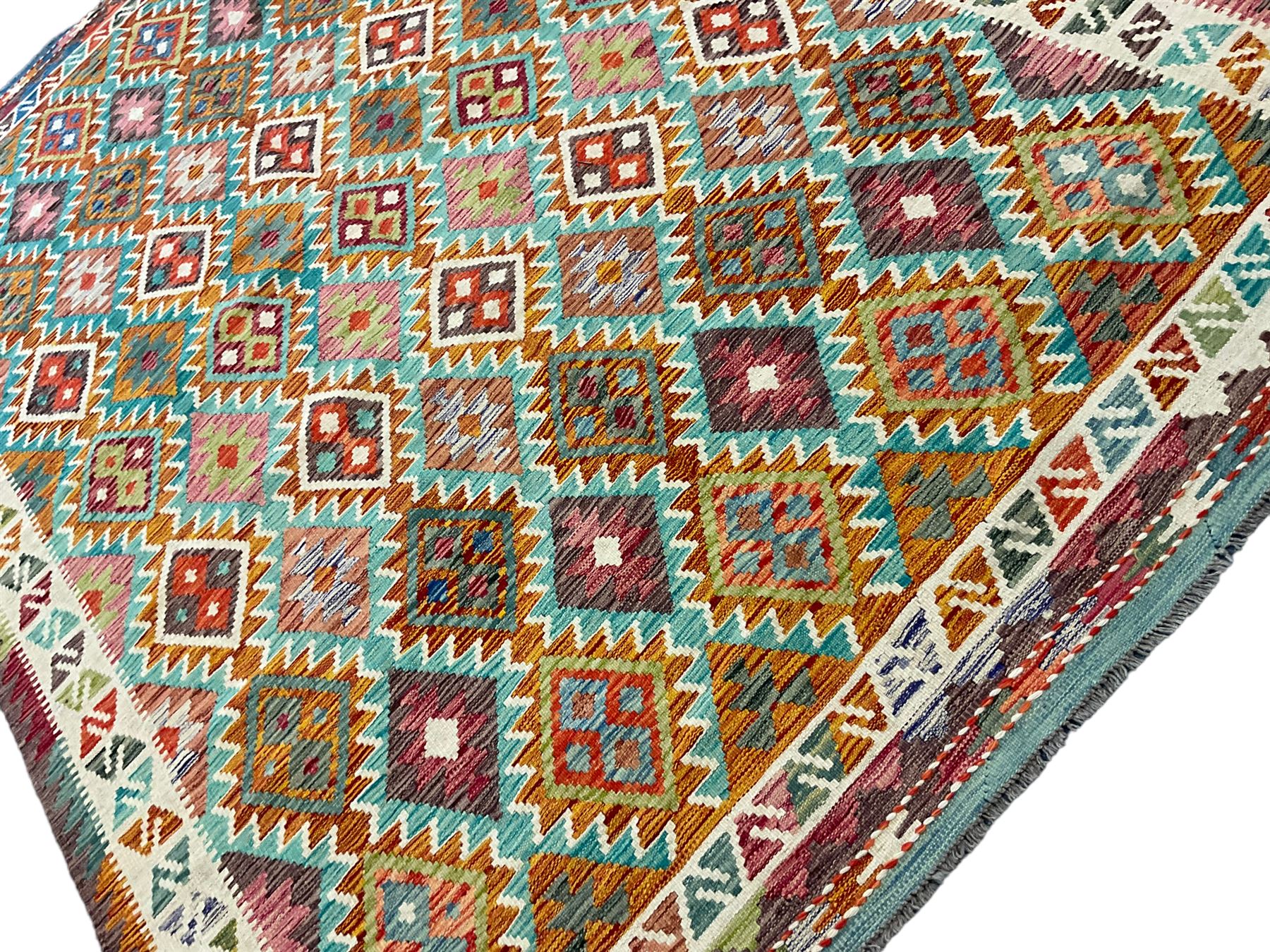 Anatolian Turkish Kilim multi-colour rug, decorated with all over lozenges in contrasting colours with ivory outline, the multi-band ivory border with repeating geometric shapes and small lozenges or diamonds