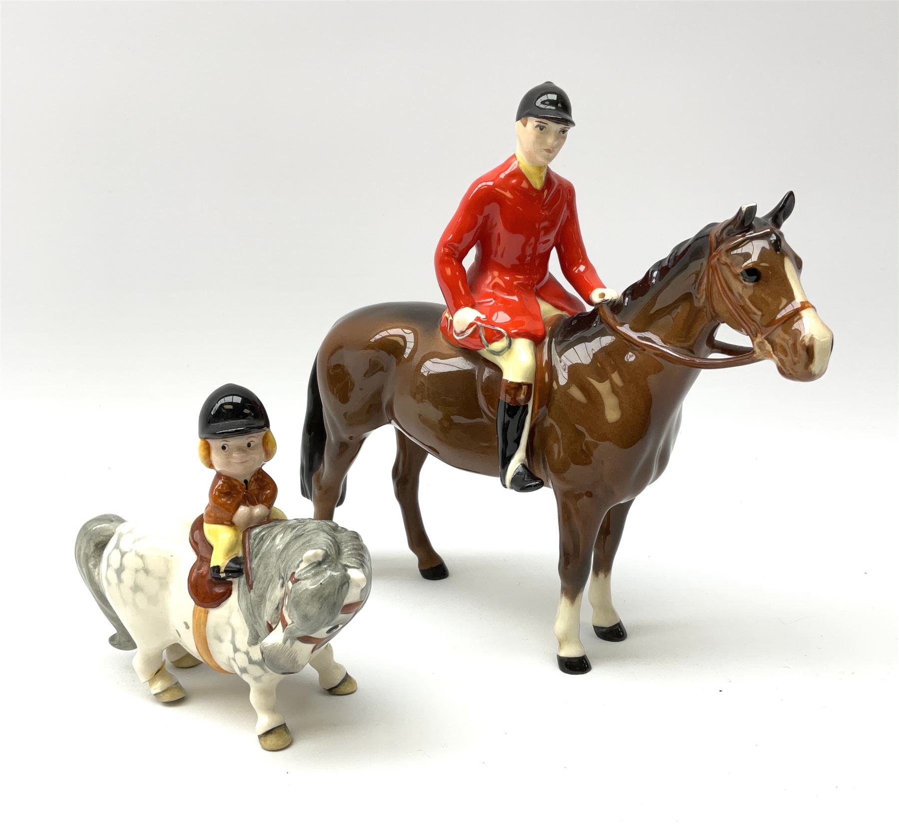 A Beswick equestrian figure modelled as a huntsman on bay horse, with printed mark beneath, together with a Beswick Norman Thelwell figure of a pony and rider, with printed mark beneath  