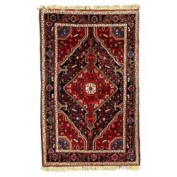 Persian Hamadan red and indigo ground rug, central lozenge medallion with extending poles, the field decorated with interlaced branches and flowerheads, guarded border with stylised floral motifs