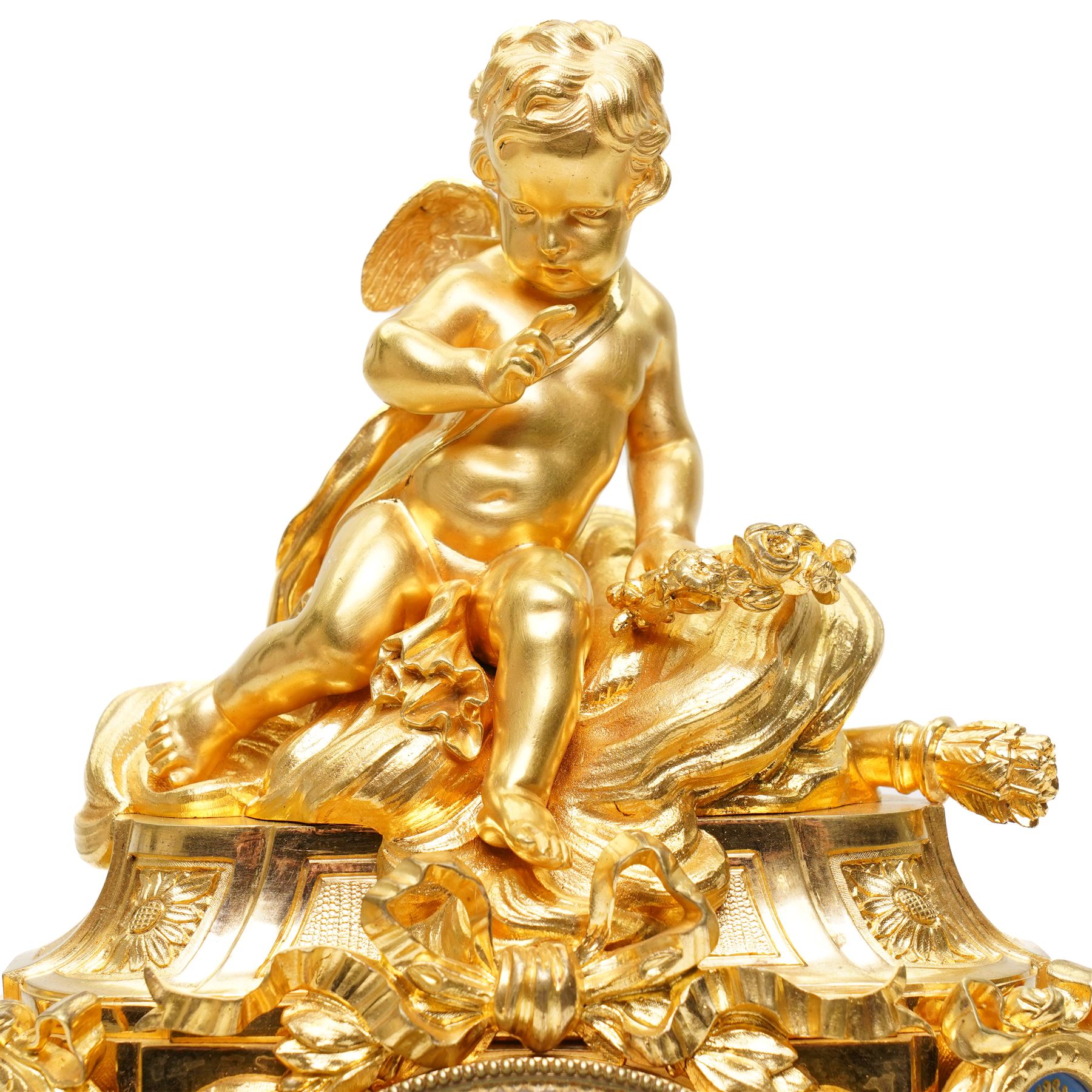 Charpentier & Cie-French 8-day mantle clock c 1860, in an ormolu case with Sevres style plaques, fluted pedestal case decorated with acanthus leaves and floral swags, surmounted by a putto and raised on toupie feet, convex enamel dial with Roman numerals, minute track and five-minute Arabic's, with makers name and Louis XVI style gilt hands, Parisian twin train movement with rack striking, sounding the hours and half-hours on a bell. With pendulum and key.
Charpentier & Cie, operated in Paris from around 1830 to 1860. They are especially well-known for their clock and garniture sets, as well as for their works of bronze. With pendulum and key.

