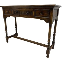 Medium oak side table, rectangular top over three drawers, on turned supports united by H-shaped stretcher rails 