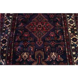 North West Persian Malayer hand-knotted runner, indigo field with vertical lozenge medallions surrounded by angular floral sprays, rosettes, and stylized palmettes, field enclosed by serrated ivory spandrels incorporating polychrome floral decoration, framed by ivory ground main border of stylized flowers and hooked devices, flanked by reciprocal guard stripes, cotton fringe ends 
