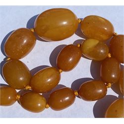 Single strand graduating oval butterscotch amber bead necklace, with three additional loose amber beads
