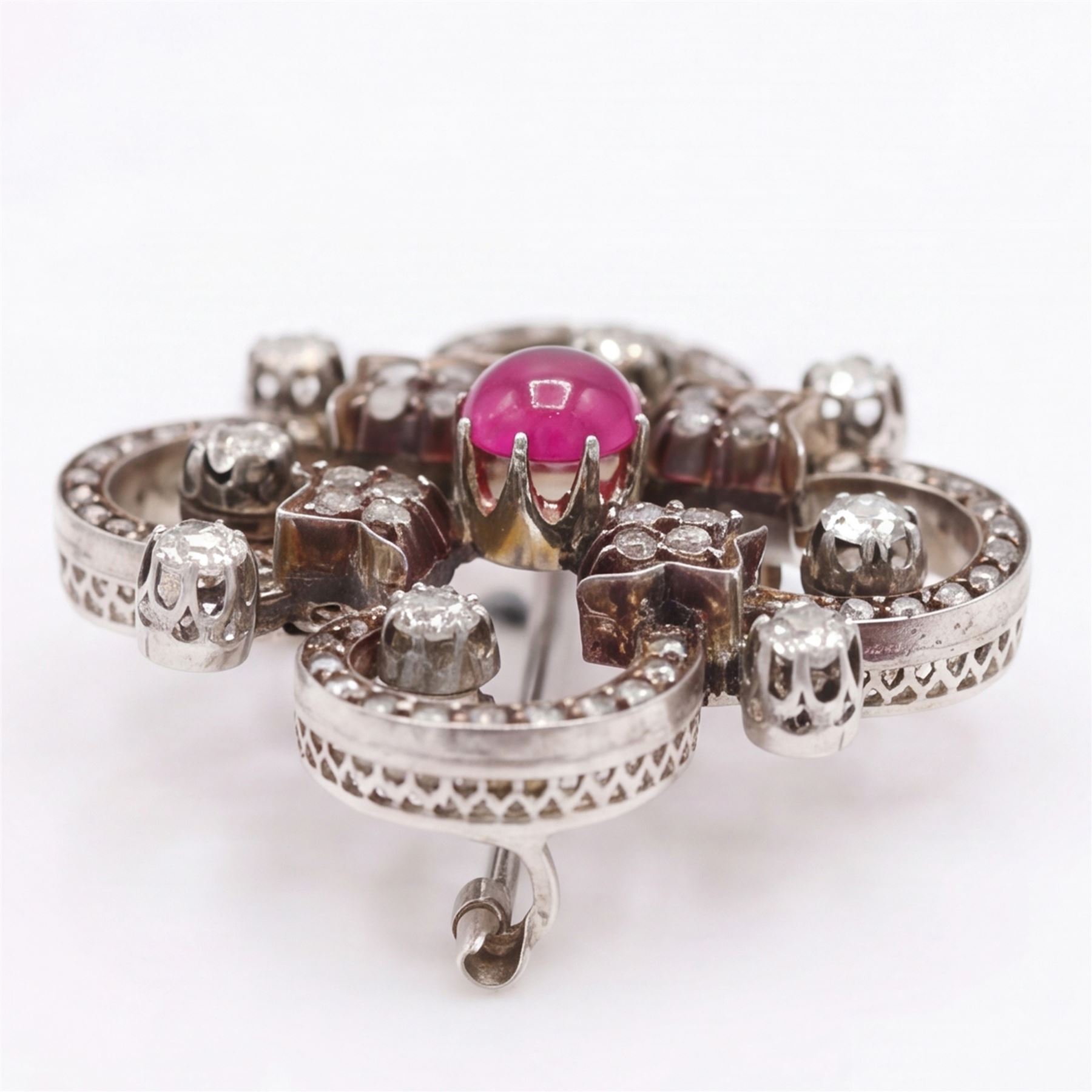 19th century French 18ct white gold ruby and diamond brooch by Eugène Fontenay, centrally set with a single cabochon cut ruby of approx 1.85 carat, the foliate scroll border set with eight old cut diamonds of approx 1.45 carat and rose cut diamonds, stamped with makers mark EF, eagles head and numbered 23960